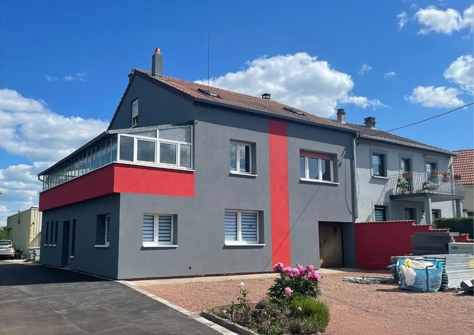 Maisons à colombages alsaciennes traditionnelles bordant un canal avec pont de pierre, balcons fleuris de géraniums roses et architecture médiévale typique